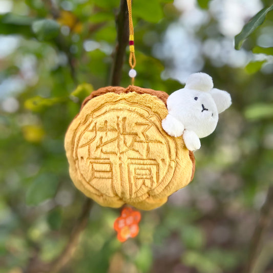 Decorative item with a plush toy attached, hanging from a tree